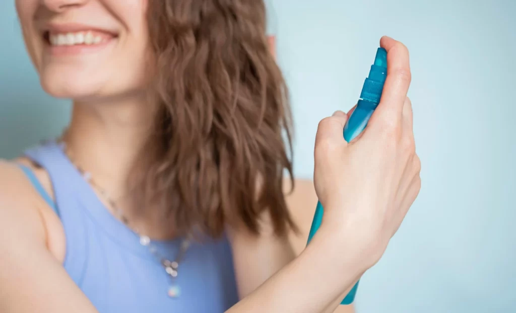 womansprayinghertexturedwavyhairwithseasaltspray Harley